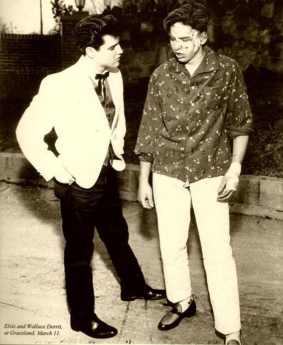 Elvis is talking to Wallis Dorritt, who was hurt in motorcycle accident about a mile from Elvis's home Graceland in 1960 right after he got out of the Army.
Elvis was riding by on his motorcycle that stopped to help offered the guy his jacket