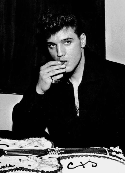 Elvis just home from the army and they had a welcome home cake and Elvis is eating the frosting, of course!