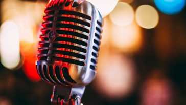 Vintage stage microphone under dramatic spotlights representing Elvis Presley in Concert